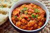 Un recipiente con chana masala decorado con cilantro fresco.