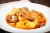 Un plato con patatas guisadas con costillas y níscalos.