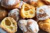 Buñuelos de viento recién hechos, uno abierto mostrando el interior esponjoso.