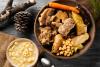 Presentación de una escudella y carn d´olla catalán con sopa de pasta y las verduras y diferentes tipos de carne al lado.