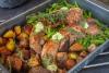 Una bandeja de horno con solomillo de cerdo al horno con patatas y judías verdes.