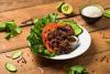 Un plato de ensalada vietnamita de carne con lechuga, pepino, cebolla morada y tomate.