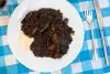 Un plato de arroz negro acompañado con alioli.