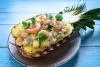 Media piña rellena de ensalada de piña y camarones.