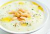 Un plato de puré de alubias blancas decorado con con alubias blancas y hierbas aromáticas.