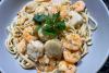Un plato de pasta Freeport decorado con piñones tostados y perejil.