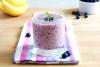 Un vaso de batido de plátano y arándanos.
