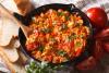 Una sartén gruesa de hierro fundido con menemem, huevos revueltos al estilo turco.