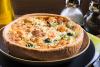 Una quiche de salmón ahumado y brócoli fotografiada en un entorno rústico.