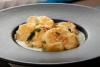 Un plato hondo gris con patatas a la importancia, una presentación elegante.