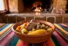 Un cuenco con picana boliviana sobre una tela típicamente andina. El fondo es una cocina rústica boliviana.