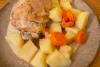 Patatas y zanahorias guisadas servidas como guarnición de pollo guisado a la cerveza.