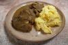 Un palto con carne guisada acompañ1ado de su salsa y puré de patata.
