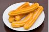 Un plato con churros recién hechos, azucarados muy ligeramente.