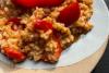 Arroz estilo risotto con tomato, pimiento rojo y mozzarella en un plato.