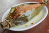 Djom, pescado cocido al vapor en hoja de plátano abierta, con cobertura espesa de pasta de semillas de calabaza, tomate y jengibre.