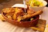 Una pierna de cordero asada al estilo tradicional, en fuente de barro.