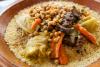Cuscús tradicional con garbanzos, zanahorias, repollo y carne guisada servido en fuente de barro.