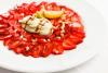 Un plato de carpaccio de fresas con ricotta, piñones y zumo de limón.