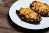 Berenjenas rellenas de carne y verduras gratinadas con queso rallado.