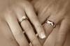Dos manos cogidas llevando anillos de matrimonio.