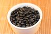 Frijoles negros en un cuenco de loza blanca.