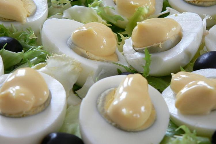 Huevos rellenos cubiertos con mayonesa.
