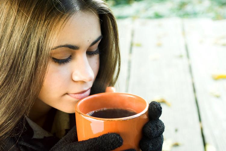 Una mujer con una taza de café en las manos durante un día frío.