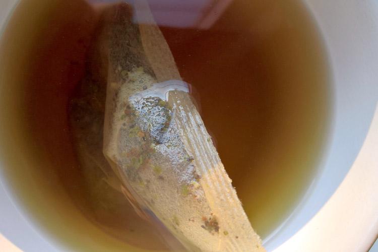 Una taza con una bolsa de té blanco en infusión.