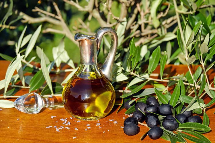 Aceite de oliva, aceitunas y hojas de olivo.
