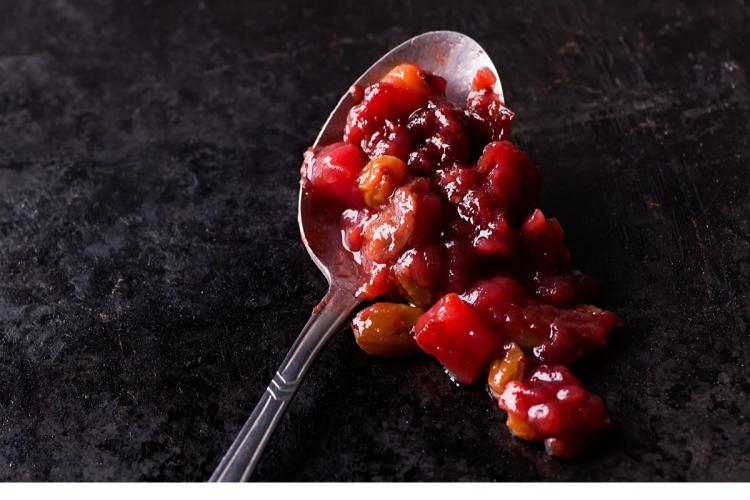 Una cucharada de chutney con pera y arándanos rojos.