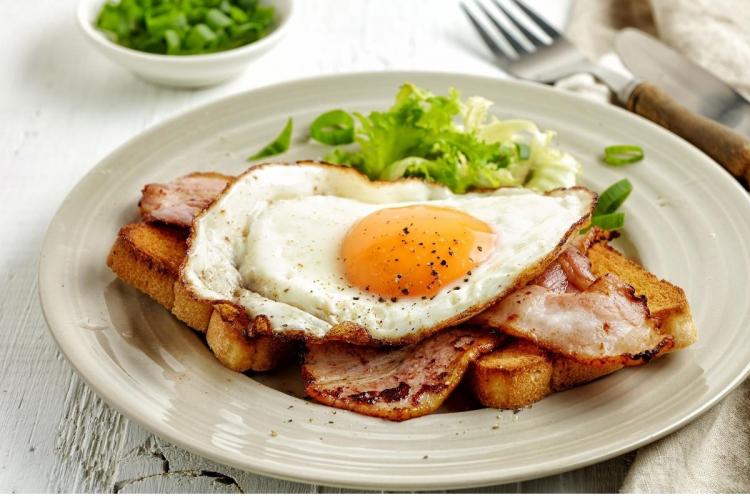 Tostada desayuno inglés con tocino frito y huevo.
