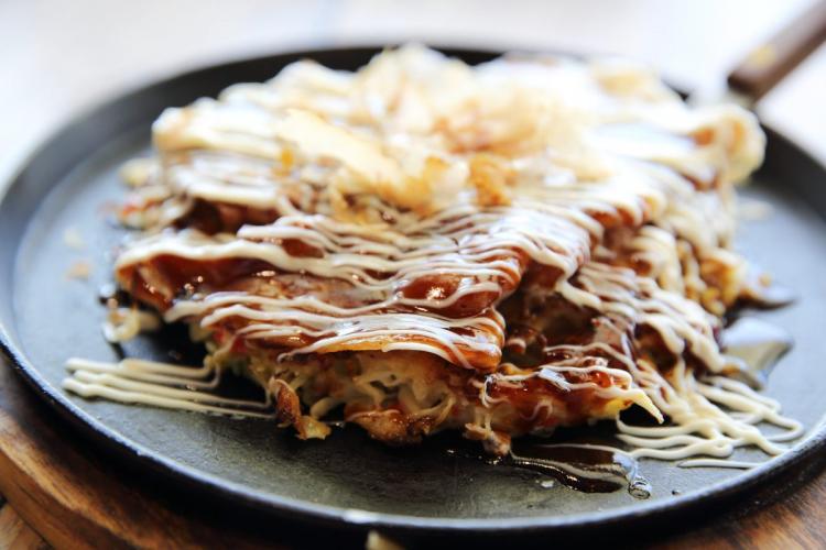 Okonomiyaki casero en una plancha individual.