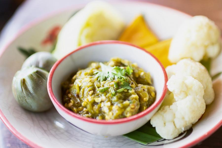 Nam prik num tradicional tailandés, su salsa de chile verde, servido con verduras frescas, incluyendo berenjena verde, coliflor y rodajas de calabaza.