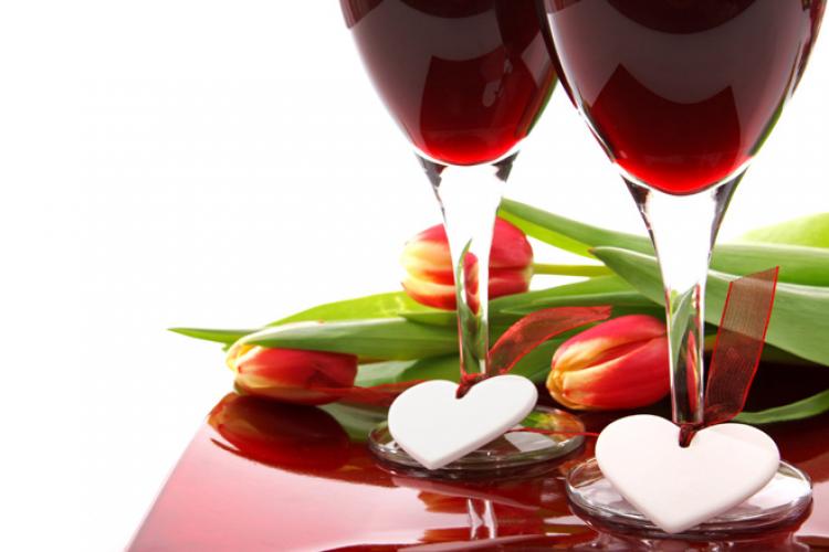 Dos copas de vino tinto adornadas con corazones.